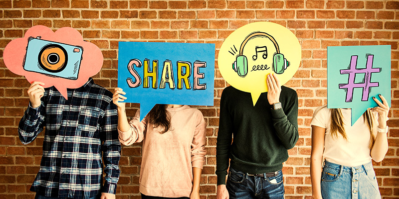 Four people holding social media signs in front of their face